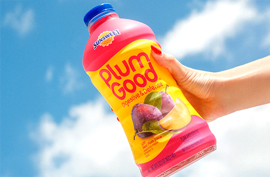 Hand holding PlumGood bottle